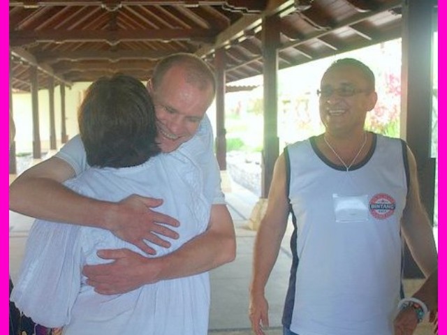 Miroslav hugs Rita while Victor watches.